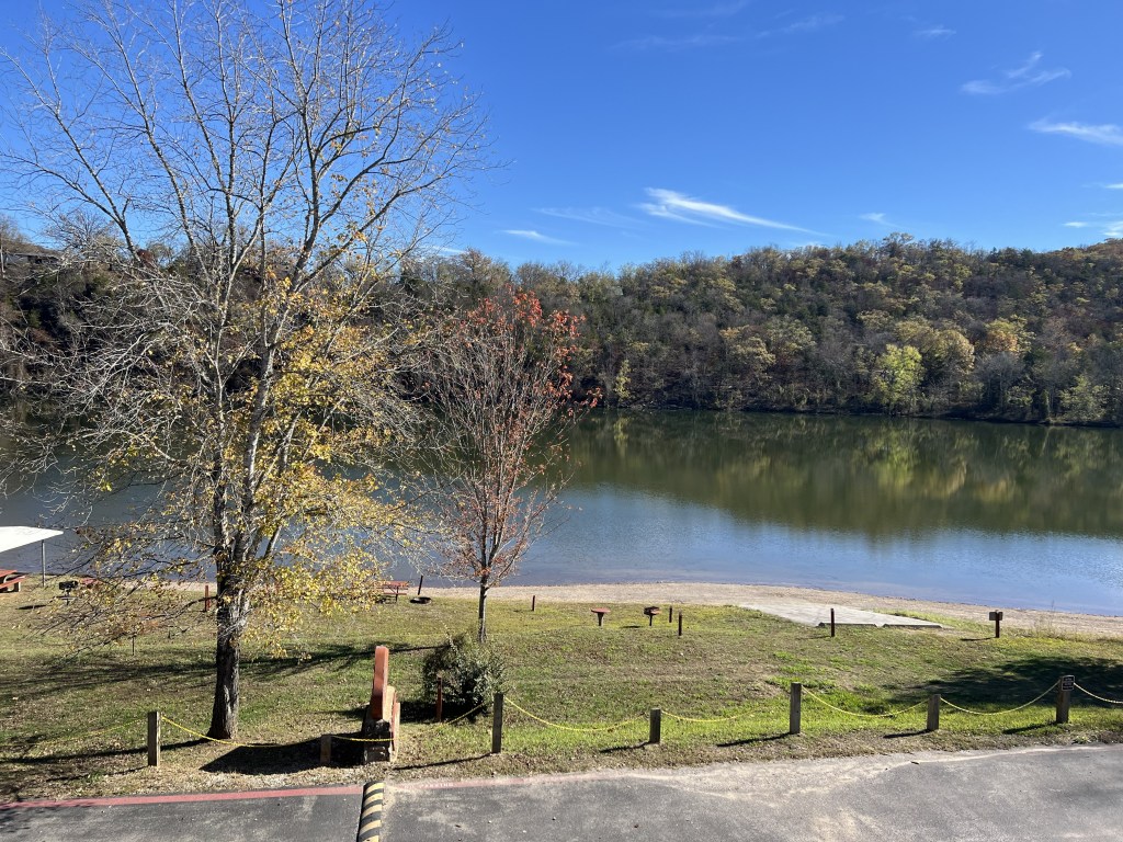 Scenic view of a river surrounded by trees in autumn, with a clear blue sky above.